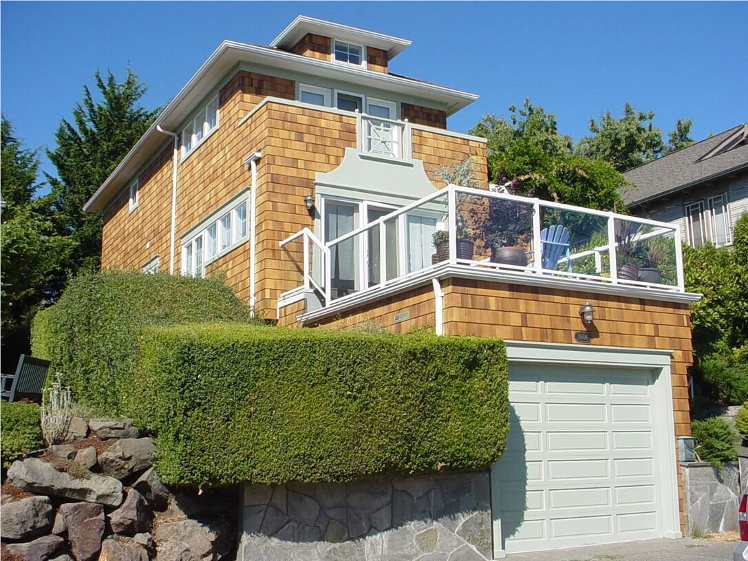 A multiple story-house with cedar shake shingle siding and a balcony