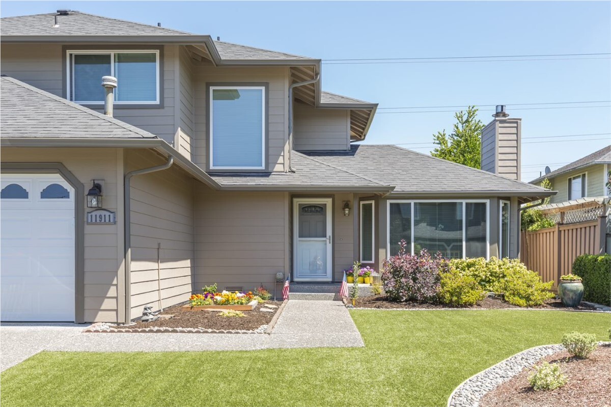 Brown house with vinyl siding and green front lawn