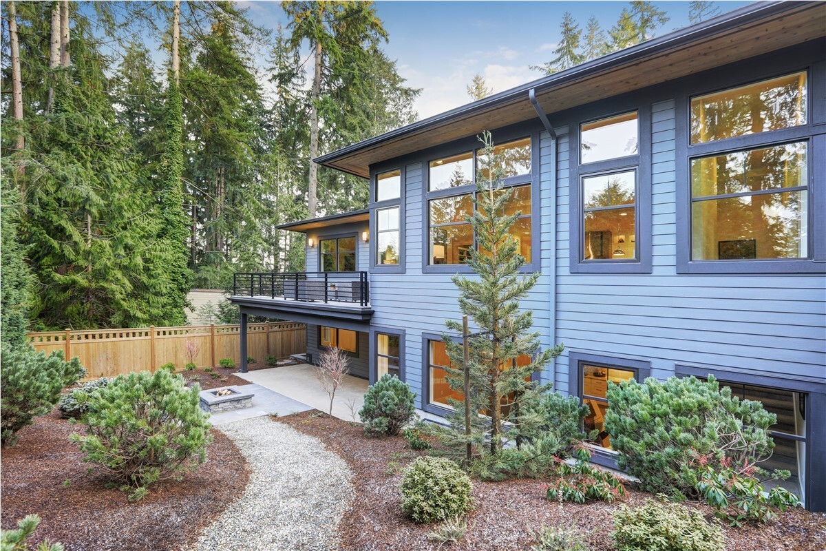 House with blue siding and pine tree landscaping