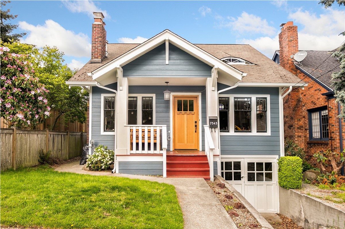 Simple one-story house with blue siding, red stairs and a wooden door