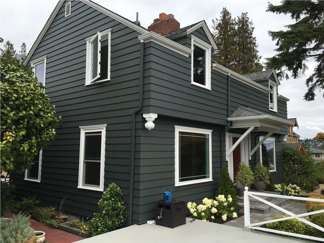 House with dark gray siding and white window trim