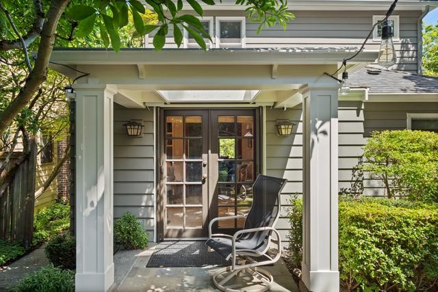 Well-lit alcove with french doors surrounded by lush greenery.