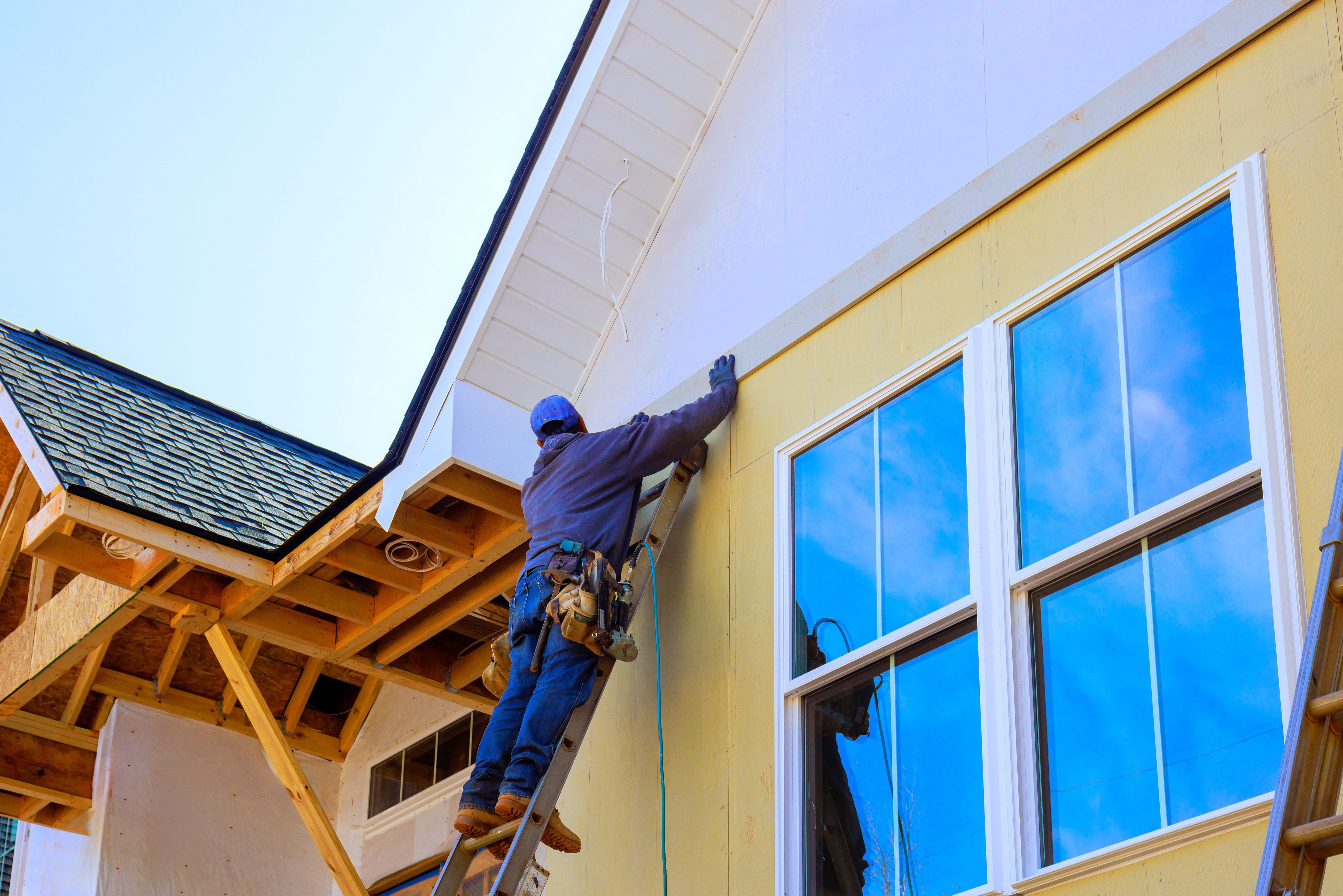 Crew-installing-siding-panels-on-home