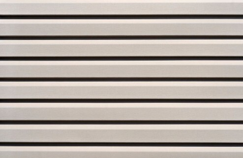 White vinyl siding close up with shadows.